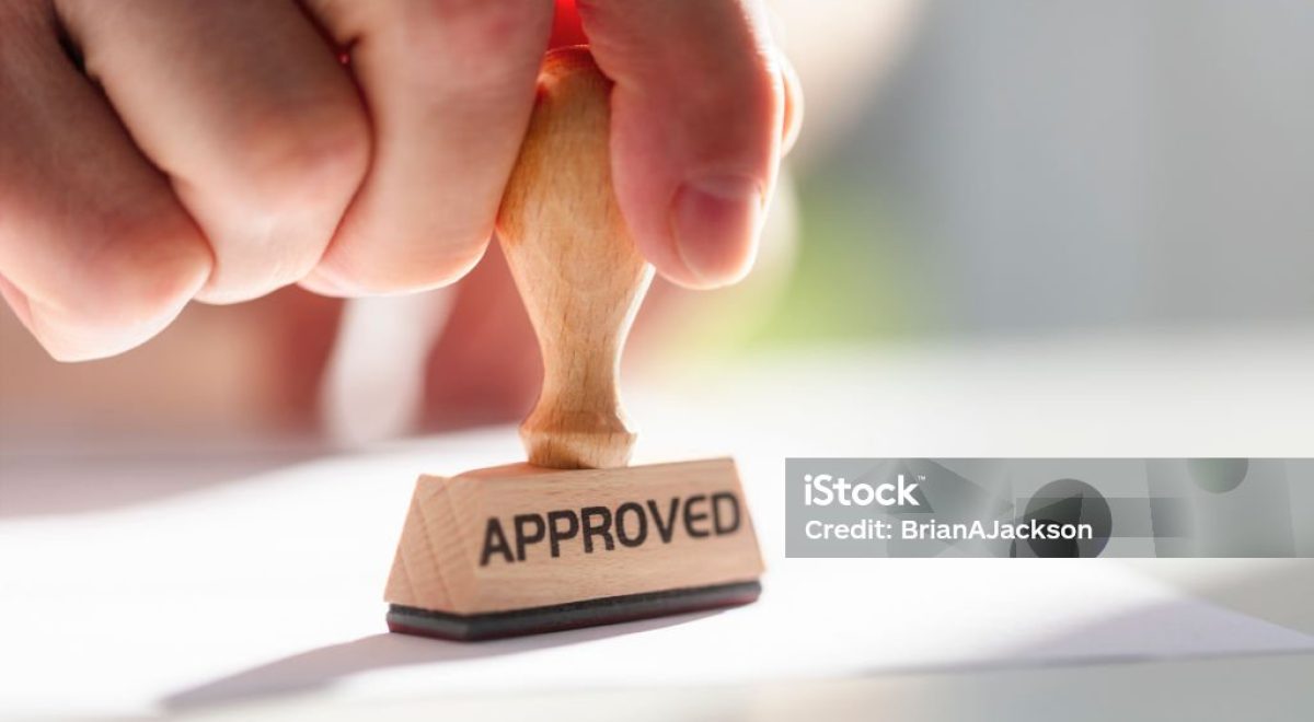 Businessman or notary public stamping approved stamp on document in meeting